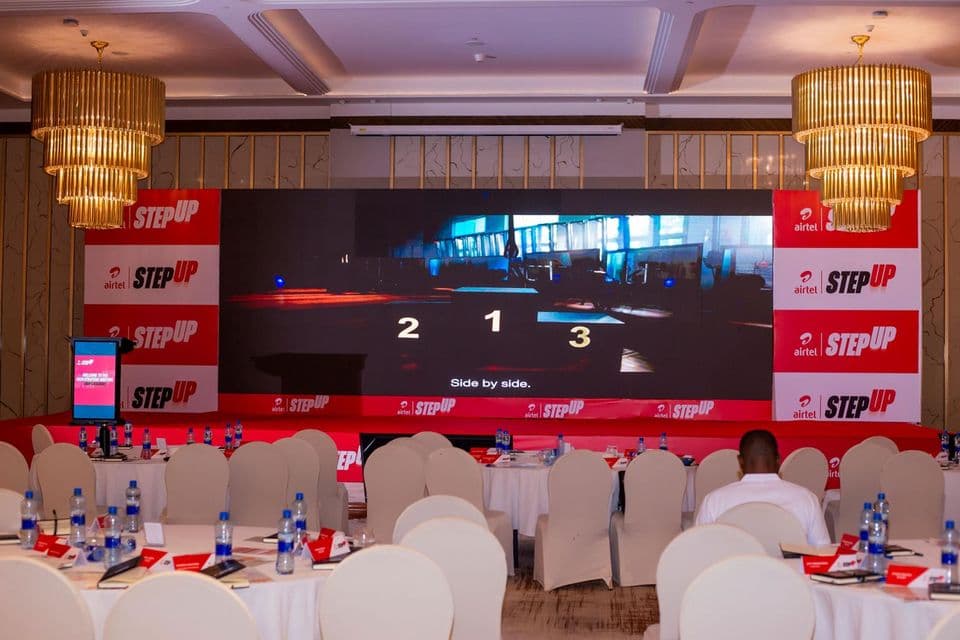 Airtel StepUp stage with a wide LED wall beneath chandeliers, framed by red StepUp branding